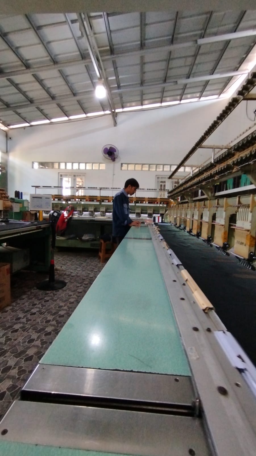 Operator bekerja di antara lini mesin bordir multi-head BAC